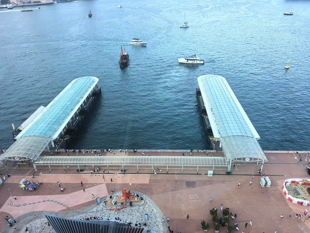 从高处俯瞰维多利亚港与天星码头，海面上还有帆船和游艇